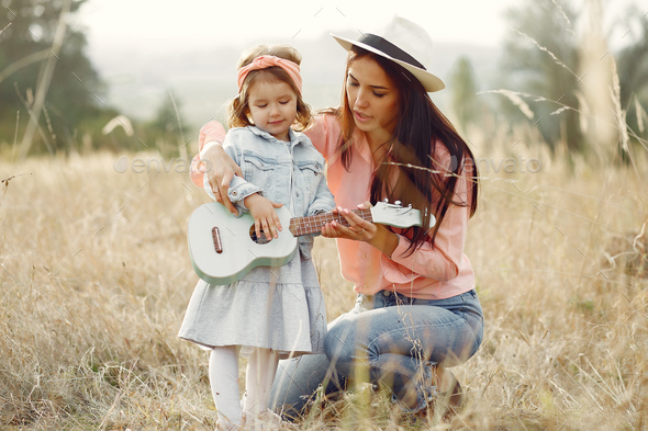 Mother with little daughter playing in a autumn field - Stock Photo - Images