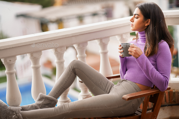 Persian woman on her balcony having a mug of coffee