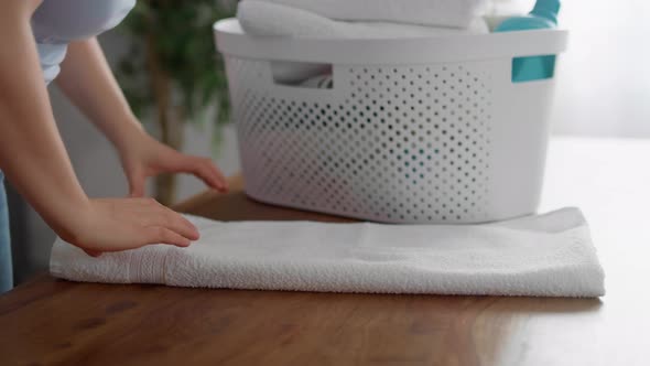 Close up of caucasian woman folding fresh towels at home. Shot with RED helium camera in 8K. alt