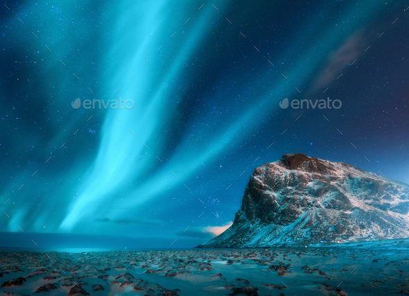 Aurora borealis above the snowy mountains and sandy beach - Stock Photo - Images