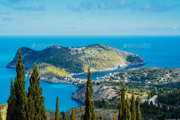 Above view to Assos village and beautiful blue sea. Cypress trees stands out in foreground - Stock Photo - Images