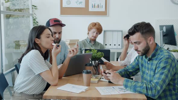 Lazy Bored Employees Playing Mobile Games Flying Paper Planes and Putting on Makeup in Office alt