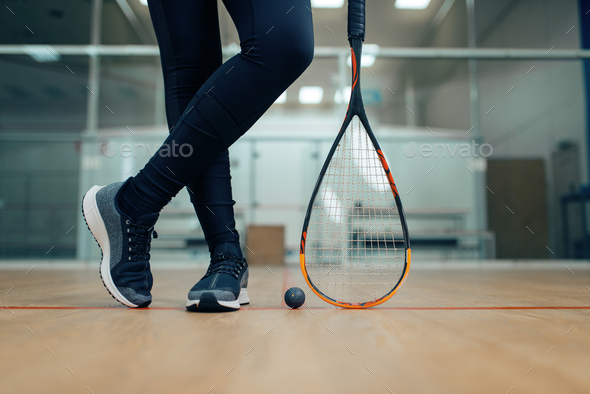 Female player legs, squash racket and ball - Stock Photo - Images