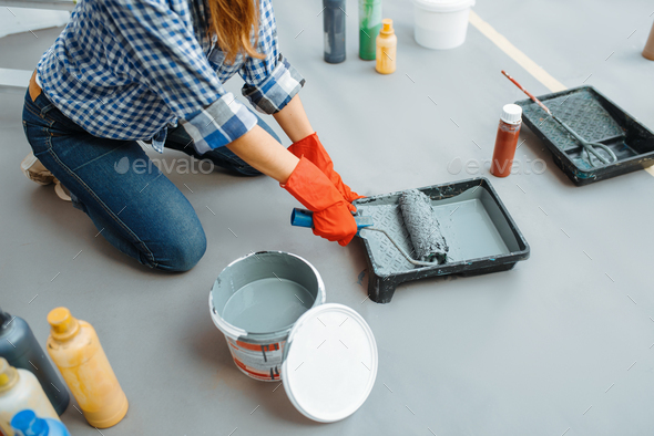 House painter impregnates the roller with paint - Stock Photo - Images