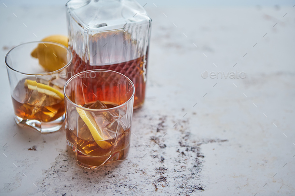Whiskey sour drink with lemon in glass on stone rustical background
