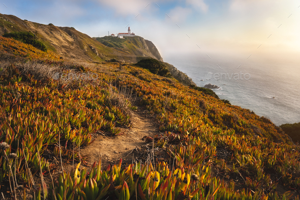 Sintra Portugal. Lighthouse on Cape Roca. Travel and hiking path lit by golden sunset light. Tourism