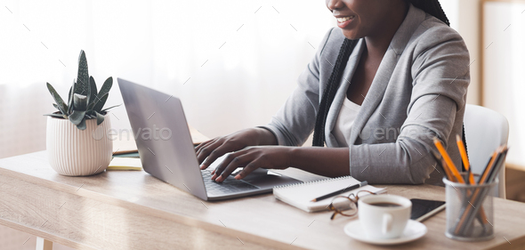 Unrecognizable african american secretary working on laptop in office