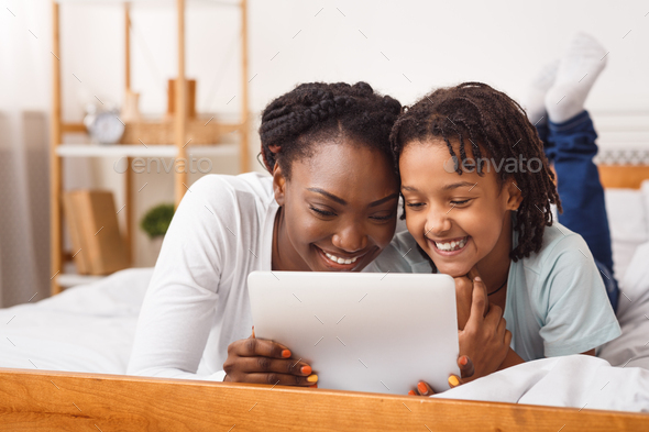 Black mother and daughter making video call to dad