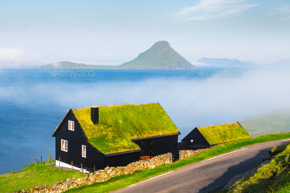 Foggy morning view of a house with typical grass roof - Stock Photo - Images