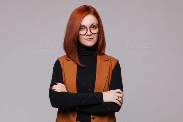 Portrait of smiling red-haired business woman in glasses posing looking at camera - Stock Photo - Images