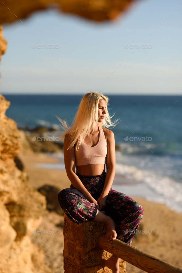 Woman enjoying the sunset on a beautiful beach - Stock Photo - Images