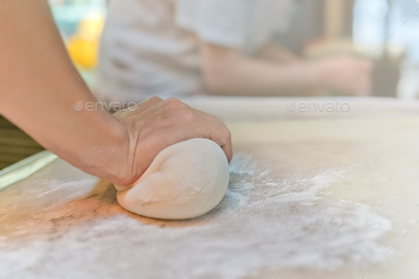 Hand rolling out the dough for chinese dumplings - Stock Photo - Images