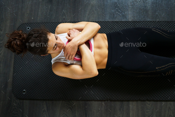 Young sportswoman on yoga mat doing situps in gym - Stock Photo - Images