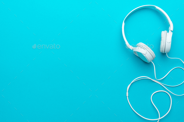 Minimal Photo Of White Headphones With Cable On Blue Background With Copy  Space. Stock Photo by garloon