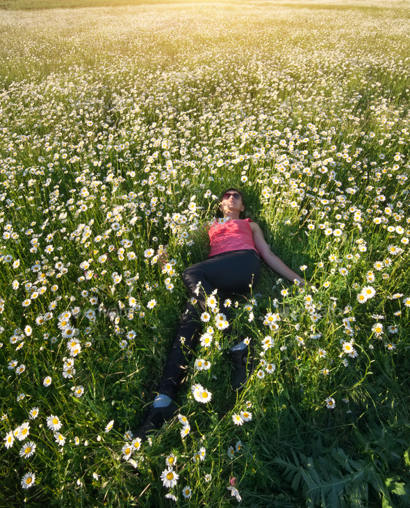 Girl in daisy wheel spring flower field.