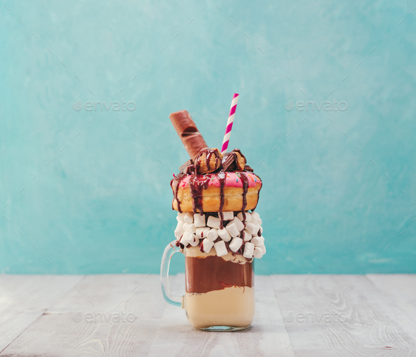 Freakshake with donuts on gray wooden background - Stock Photo - Images