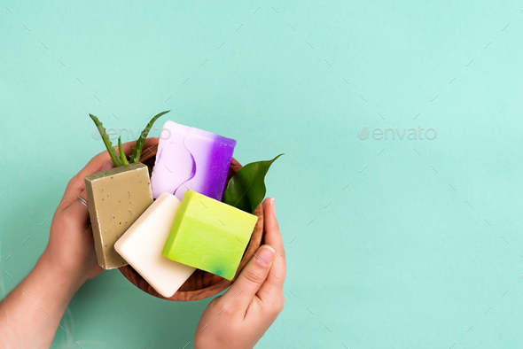 Woman hands holding natural organic color soap bar on blue background. Healthy lifestyle, beauty - Stock Photo - Images