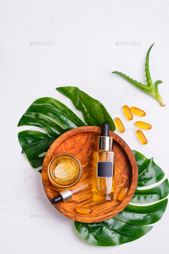 Cosmetic bottle with oil or hyaluronic acid and jar with mask for the face, Omega-3 gel capsules on - Stock Photo - Images