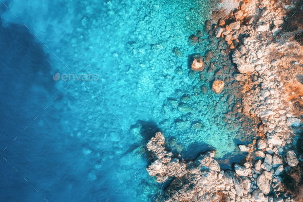 Aerial view of rocky beach and sea with transparent blue water - Stock Photo - Images