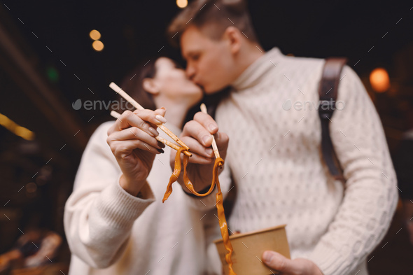 newlywed couple eating noodles with chopsticks in Shanghai outside a food market - Stock Photo - Images