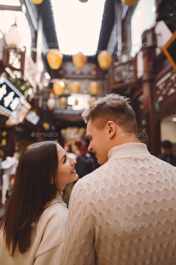 newlywed couple showing affection and holding hands in Shanghai near Yuyuan while visiting China - Stock Photo - Images