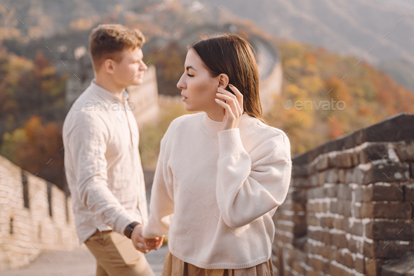 beautiful young couple holding hands and showing affection at the Great Wall of China - Stock Photo - Images
