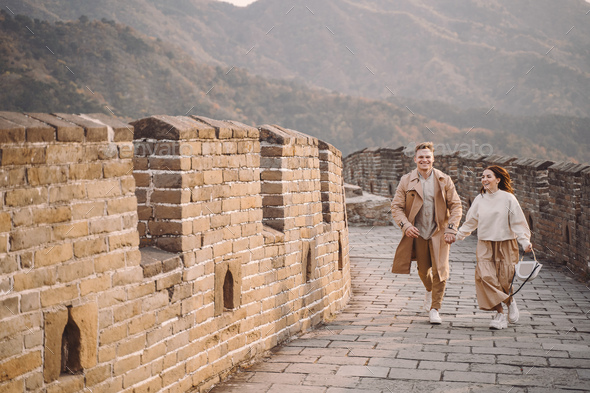 young couple running and twirling at the Great Wall of China - Stock Photo - Images