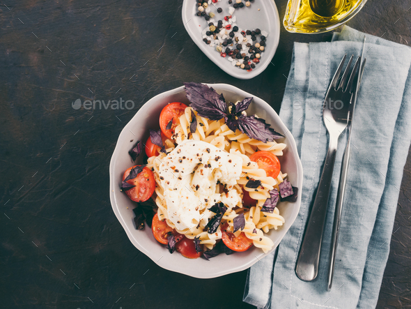 Pasta fusilli with cherry, mozarella and basil - Stock Photo - Images