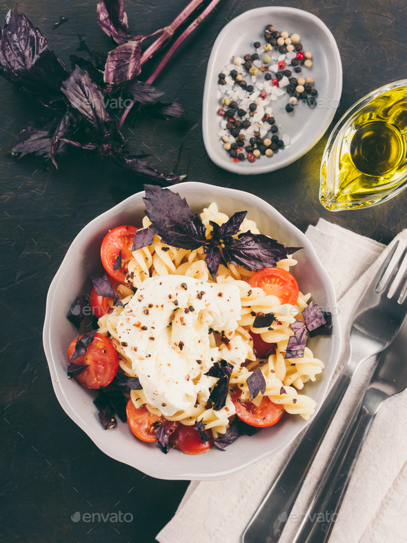Pasta fusilli with cherry, mozarella and basil - Stock Photo - Images