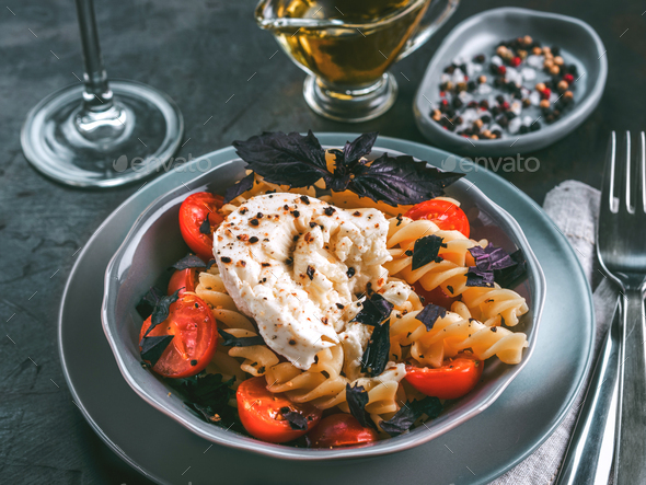 Pasta fusilli with cherry, mozarella and basil - Stock Photo - Images