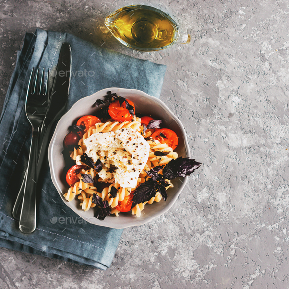 Pasta fusilli with cherry, mozarella and basil - Stock Photo - Images