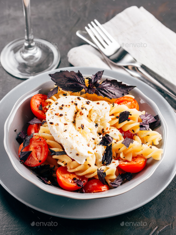 Pasta fusilli with cherry, mozarella and basil - Stock Photo - Images