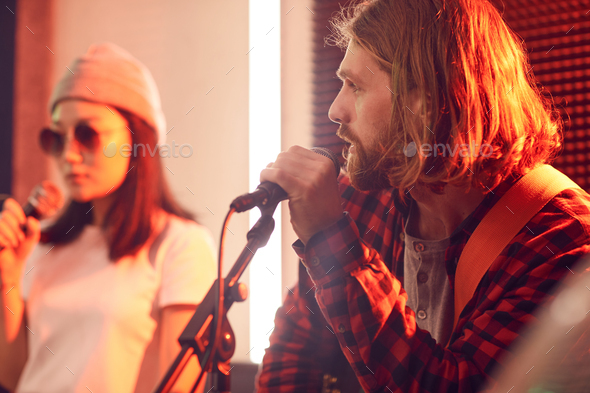 Handsome Young Man Singing with Band in Studio - Stock Photo - Images