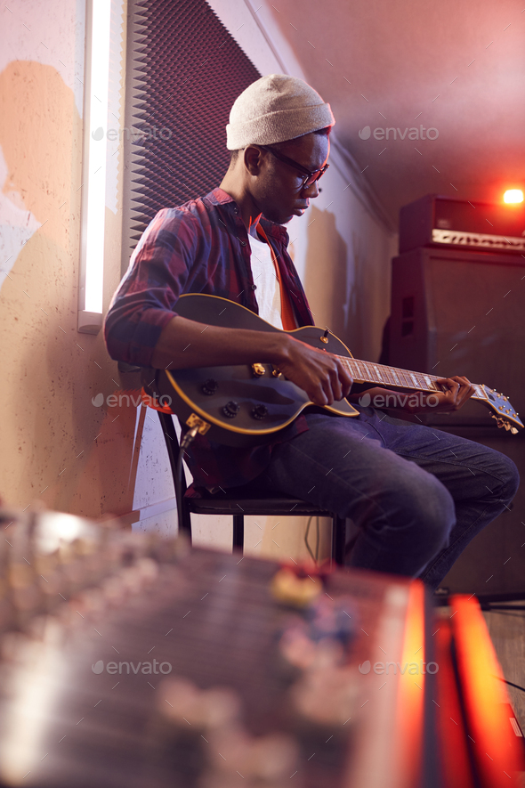 Young African Man Playing Guitar in Studio