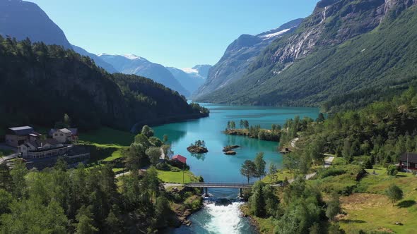 Lovatnet lake bottom with bridge crossing river and panoramic view of glacier-green freshwater surro alt