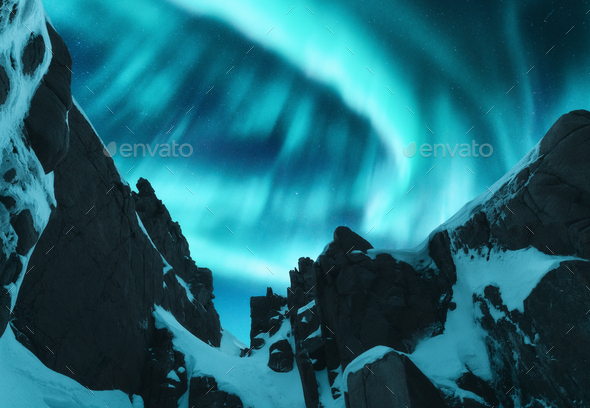 Aurora borealis above the snow covered mountain peak - Stock Photo - Images