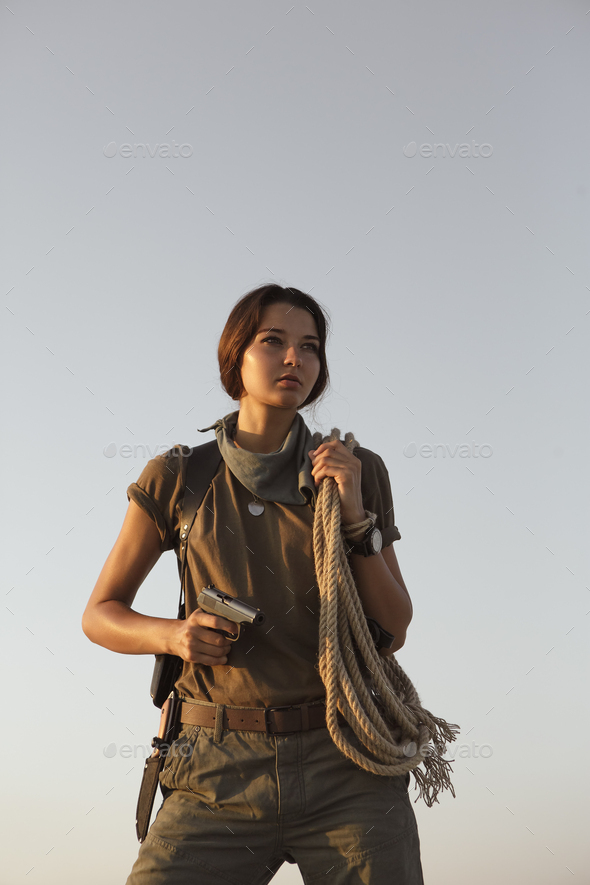Woman Standing With a Gun Outdoors in Desert