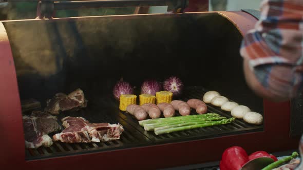 Steaks and Fresh Asparagus with Corn Grilled on the Barbecue in the Flames