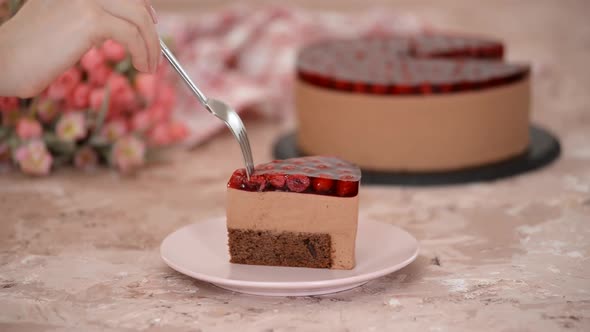 Piece of delicious chocolate mousse cake with cherry jelly on top.	