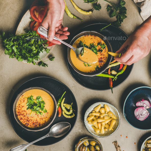 Man eating turkish traditional lentil soup Mercimek with pickled peppers - Stock Photo - Images