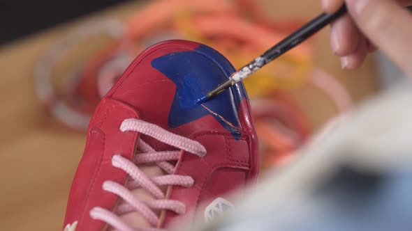 Closeup of Artist Fixing Sneakers Design By Painting It with Brush alt
