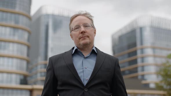 Portrait of Serious Plump Man in Suit Looking Into Camera Standing Outside the Business Office
