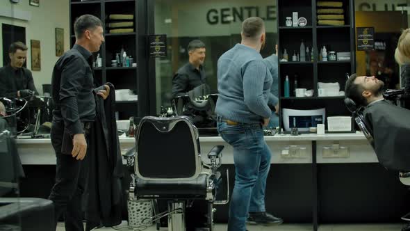 A Satisfied Client Shakes Hands with His Hairdresser alt