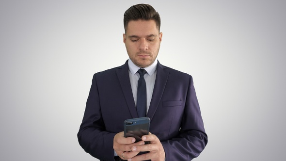 Serious businessman texting message on his phone on gradient alt