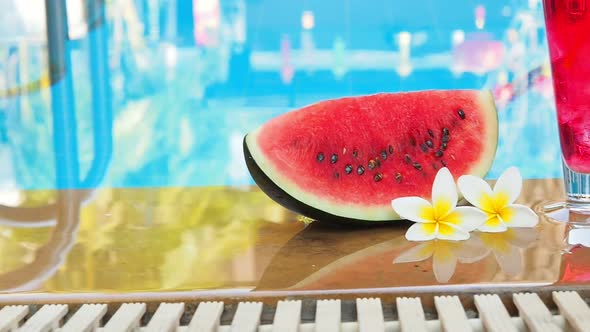 Summer holiday tropical concept. Fresh  water melon and water melon juice on border of a swimming po