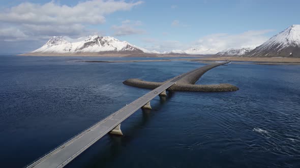 Following from above a single car driving across the Viking sword bridge towards the Peninsula alt