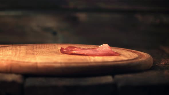 Super Slow Motion Pieces of Dried Meat Fall on the Cutting Board alt