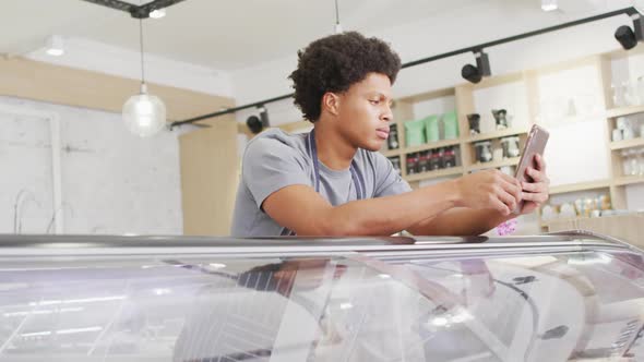 Animation of happy biracial waiter using tablet at coffee shop alt