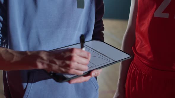 International Basketball Game the Coach Instructs Players on the Tactics of the Game Using a Tablet alt