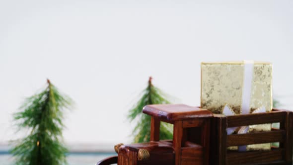 Toy tempo carrying christmas present on wooden plank alt